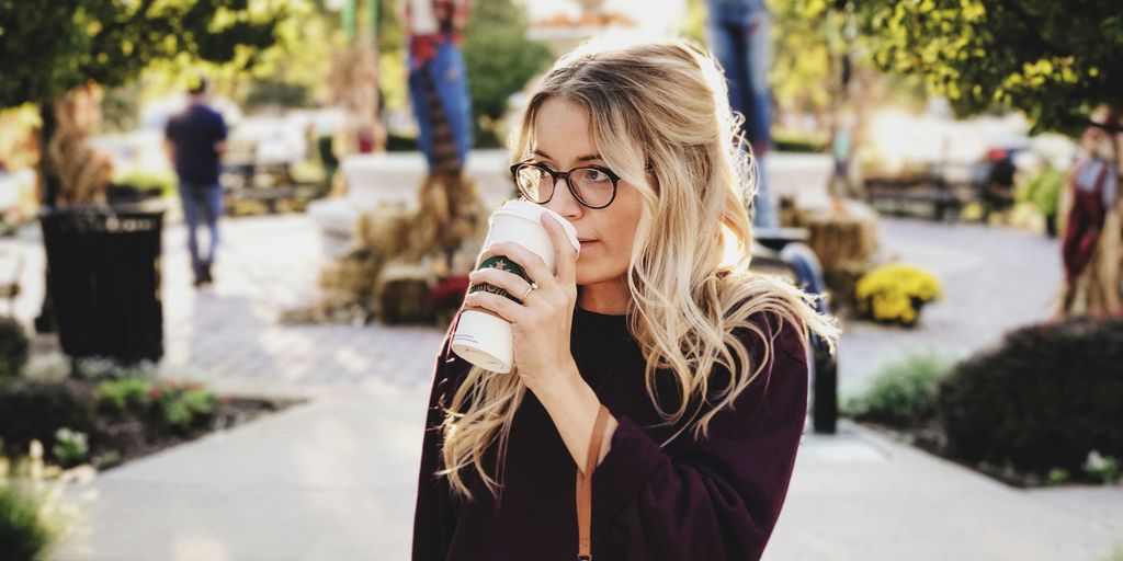 woman drinking on white cup