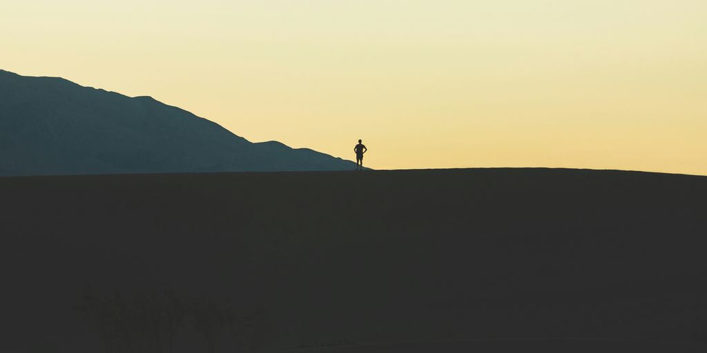 silhouette of person standing on mountain