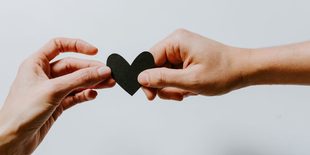 two person holding papercut heart