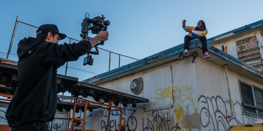 man taking a video of a person on roof